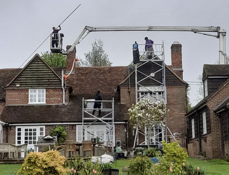 The Roof Moss Cleaners using cherry picker and scaffolding to clean roof safely and professionally in Four Marks, Hampshire